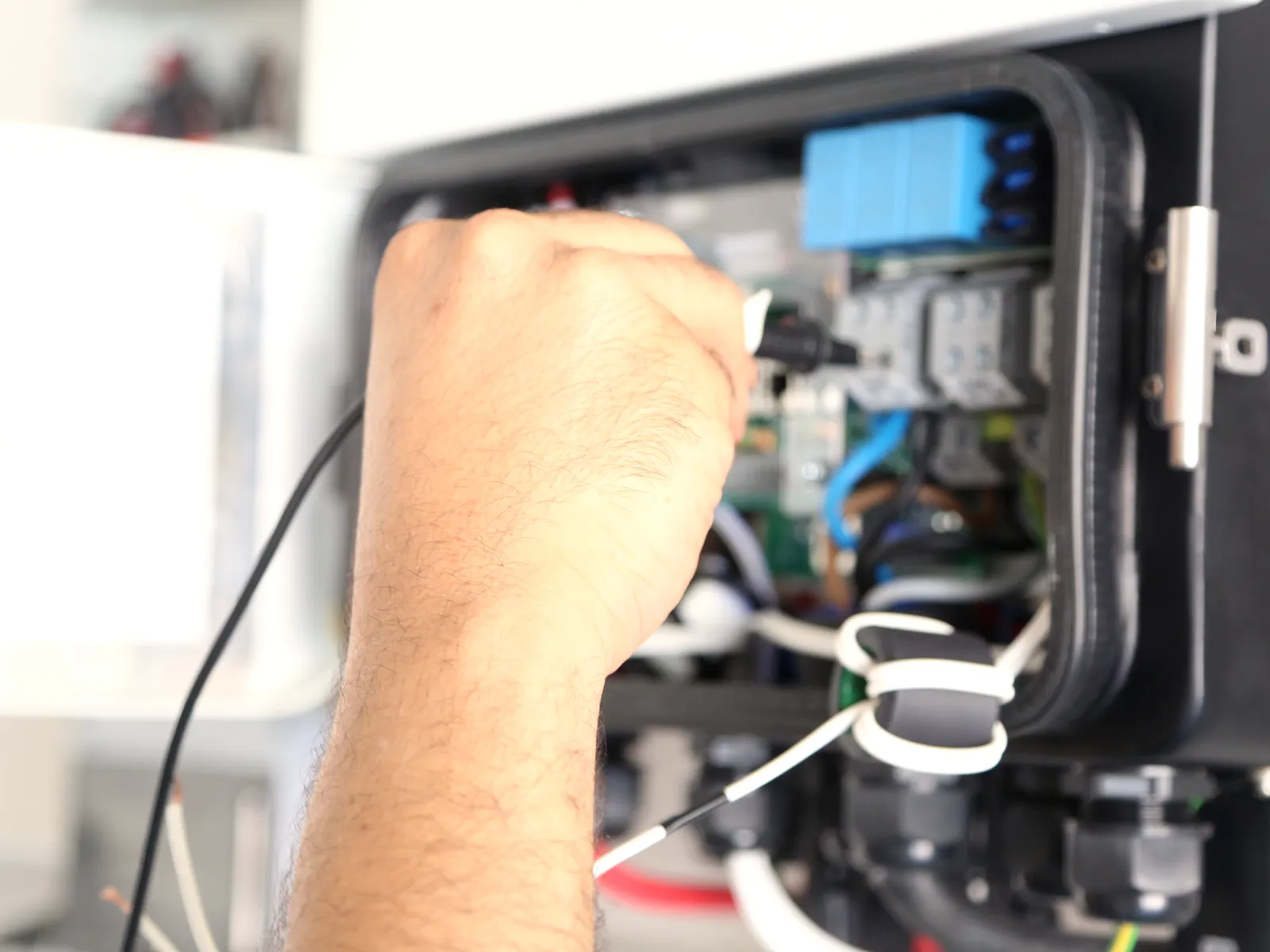 Un technicien Taqinor raccorde un coffret électrique, chantier de Bouskoura