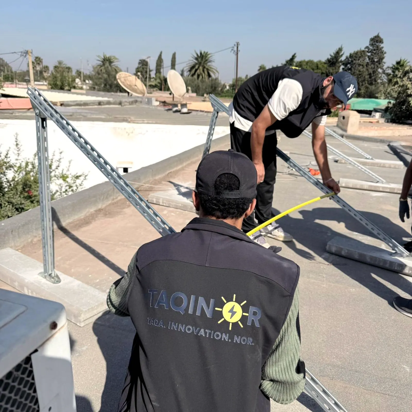 Installateur en gilet Taqinor posant les rails d'une structure, Nouaceur